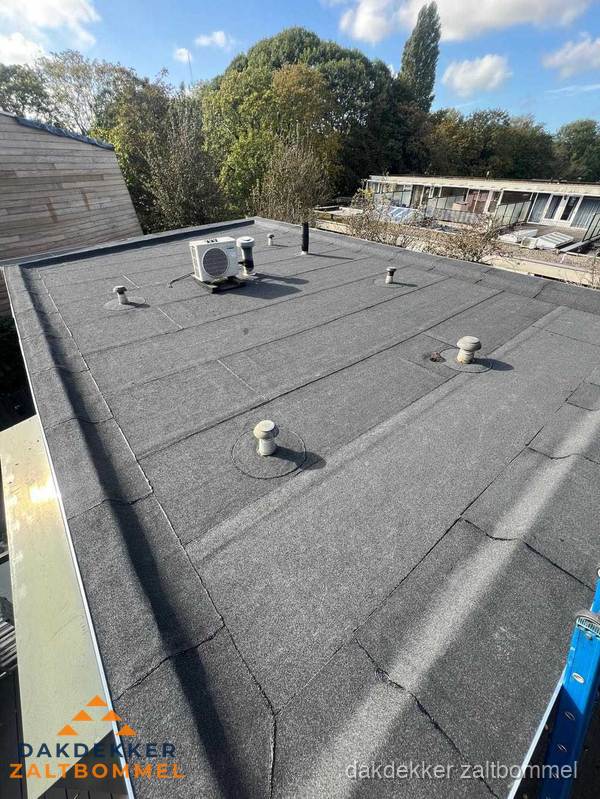 Plat dak met bitumen dakbedekking tussen bakstenen muren in Zaltbommel